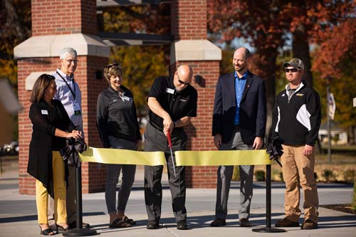 President Dave McFadden cuts the ribbon at the Bell Tower ceremony