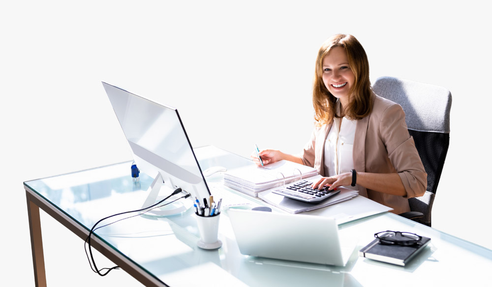An alumni sits as a CPA behind their desk.