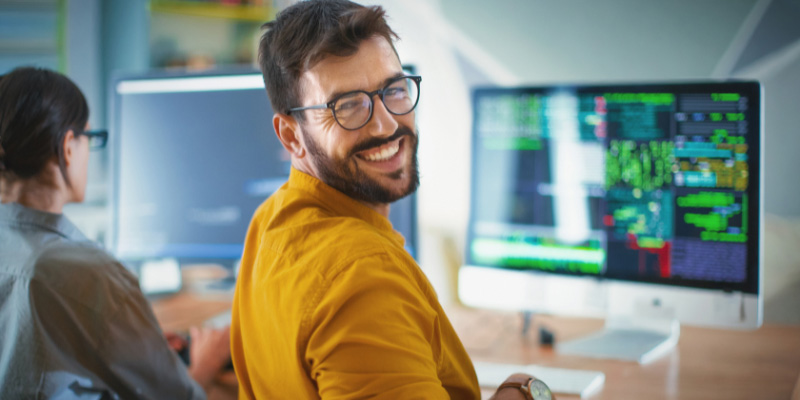 An adult education student smiles over his shoulder.