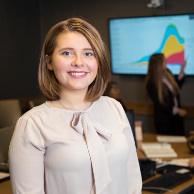 A student poses for a photo in the College of Business at MU.