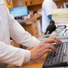 Pharmacist types at keyboard