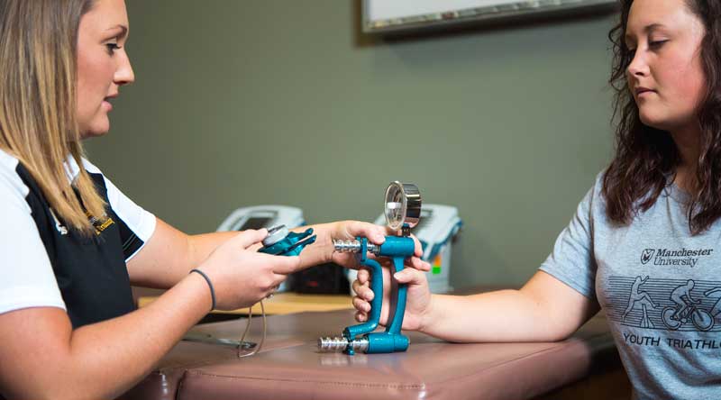 Two students calibrate an instrument used in the orthopedic studies minor