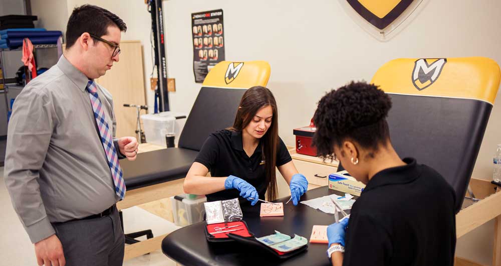 Lucas Dargo leads a class in preparing sutures