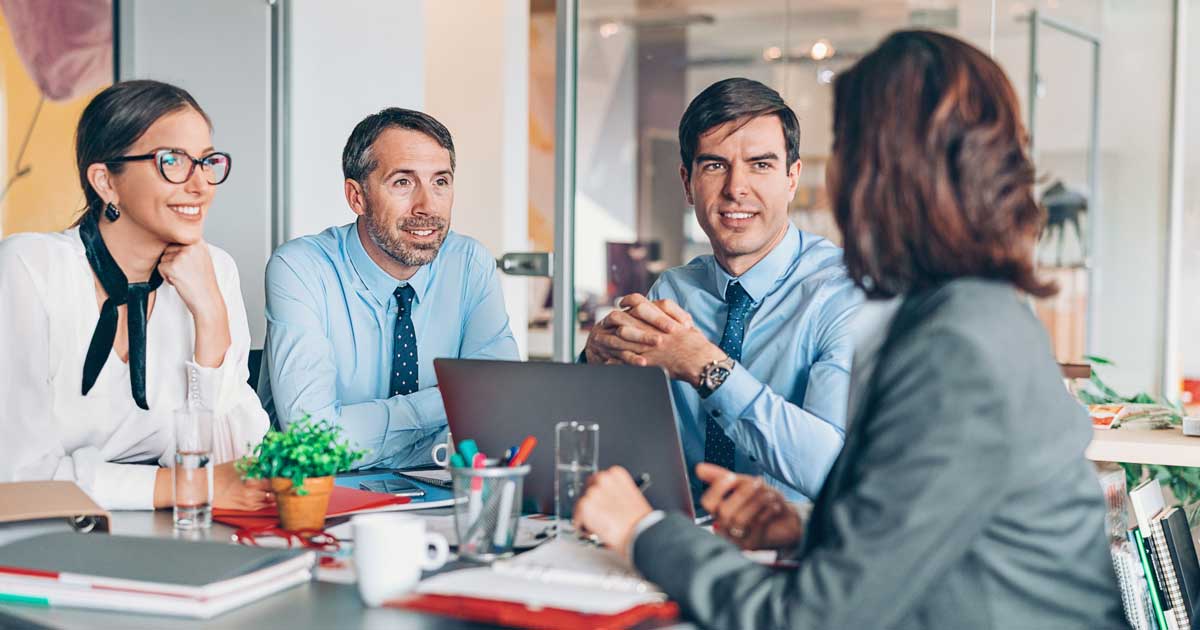 Business leaders share ideas around a table.