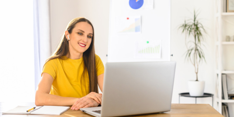 Image displays a woman working at her desktop computer.