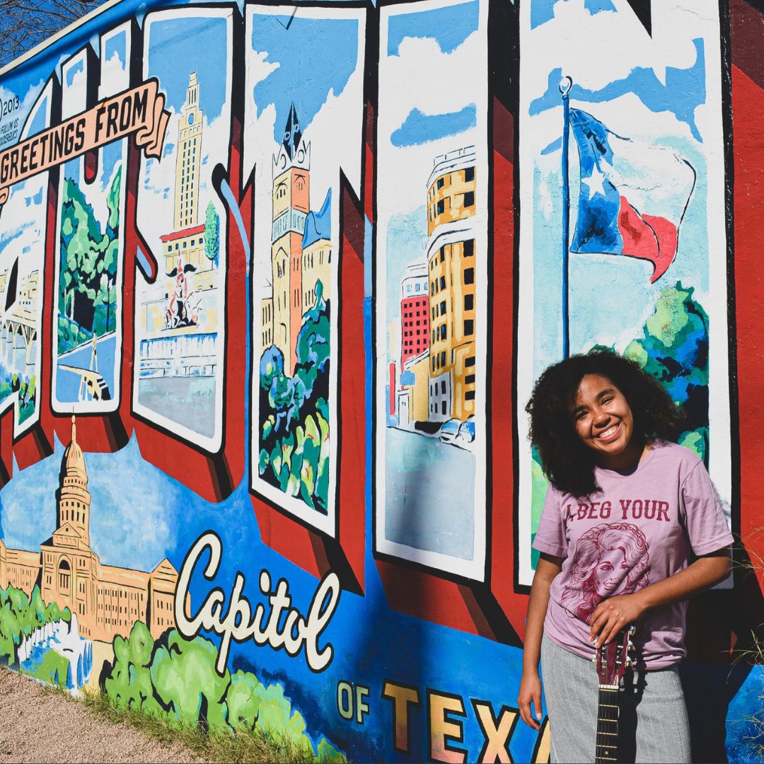 Renae Walker-Zamora posing with an Austin, TX mural