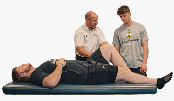 Professor Jeff Beer demonstrates proper technique during an exercise science lab.