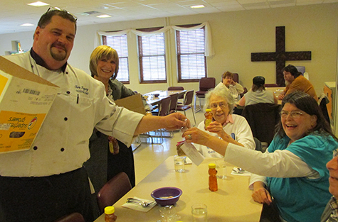 Manchester University Executive Chef Chris Fogerty, left, and Carole Miller-Patrick distribute locally produced honey at a Community Dinner. 
