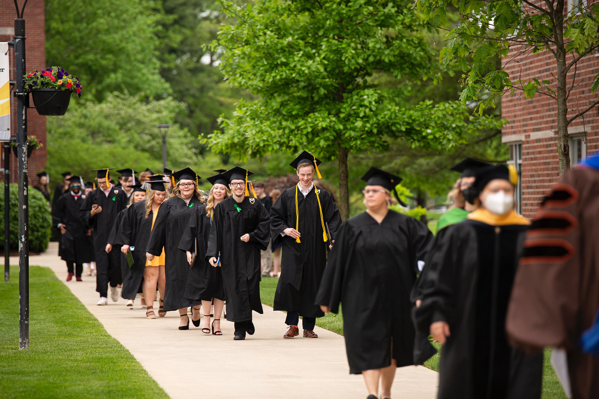 Commencement students walking outside Commencement students walking outside