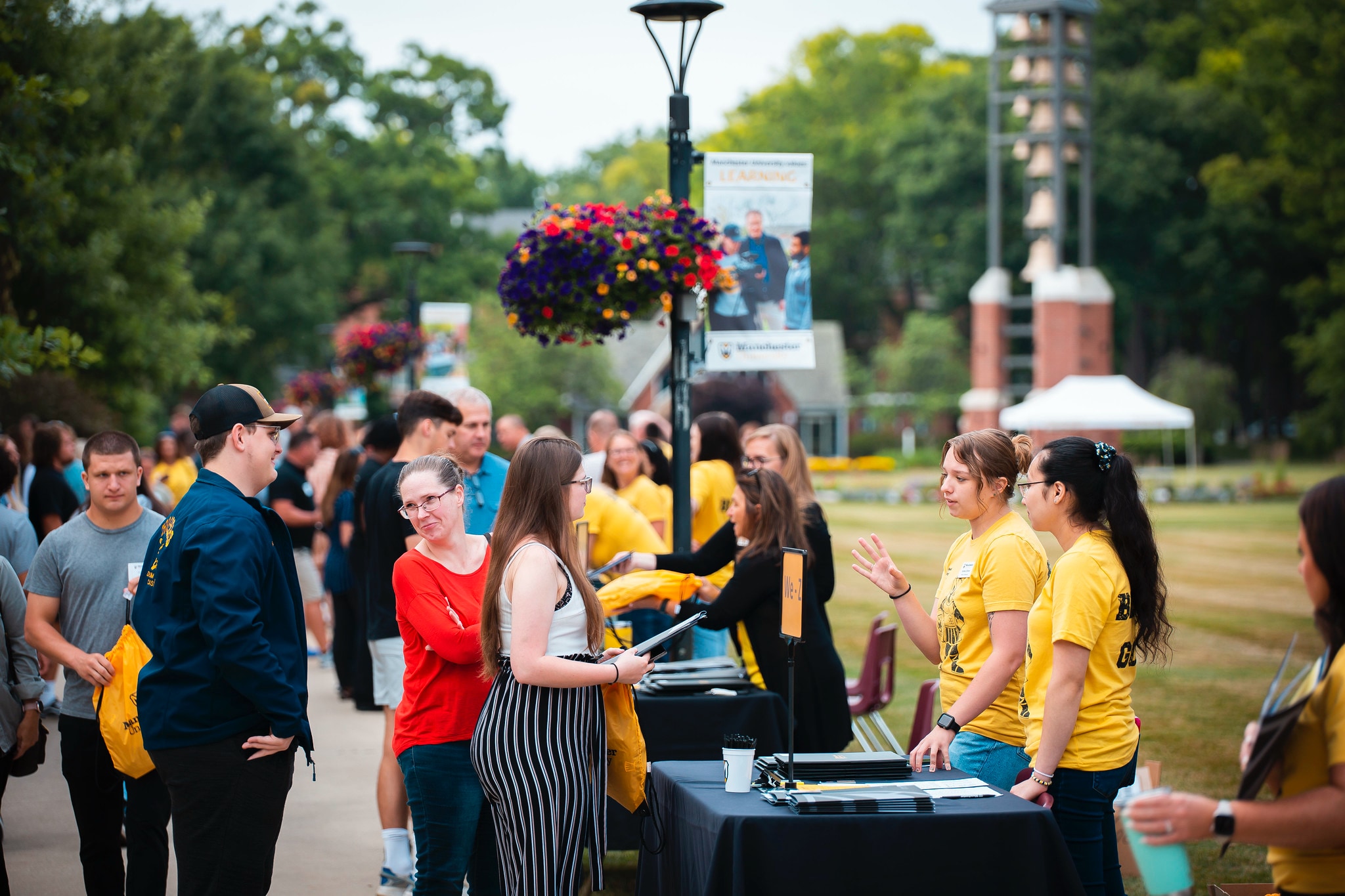 Admission Visit Day Black and Gold outside students and family at tables