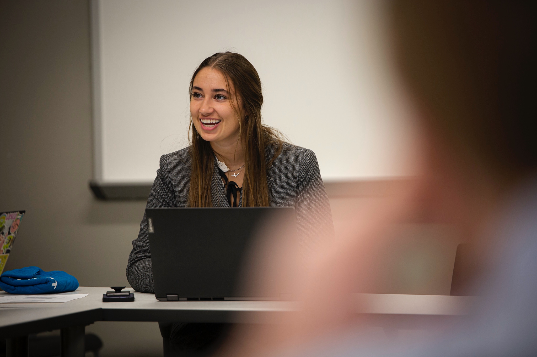 female business student in classroom with laptop