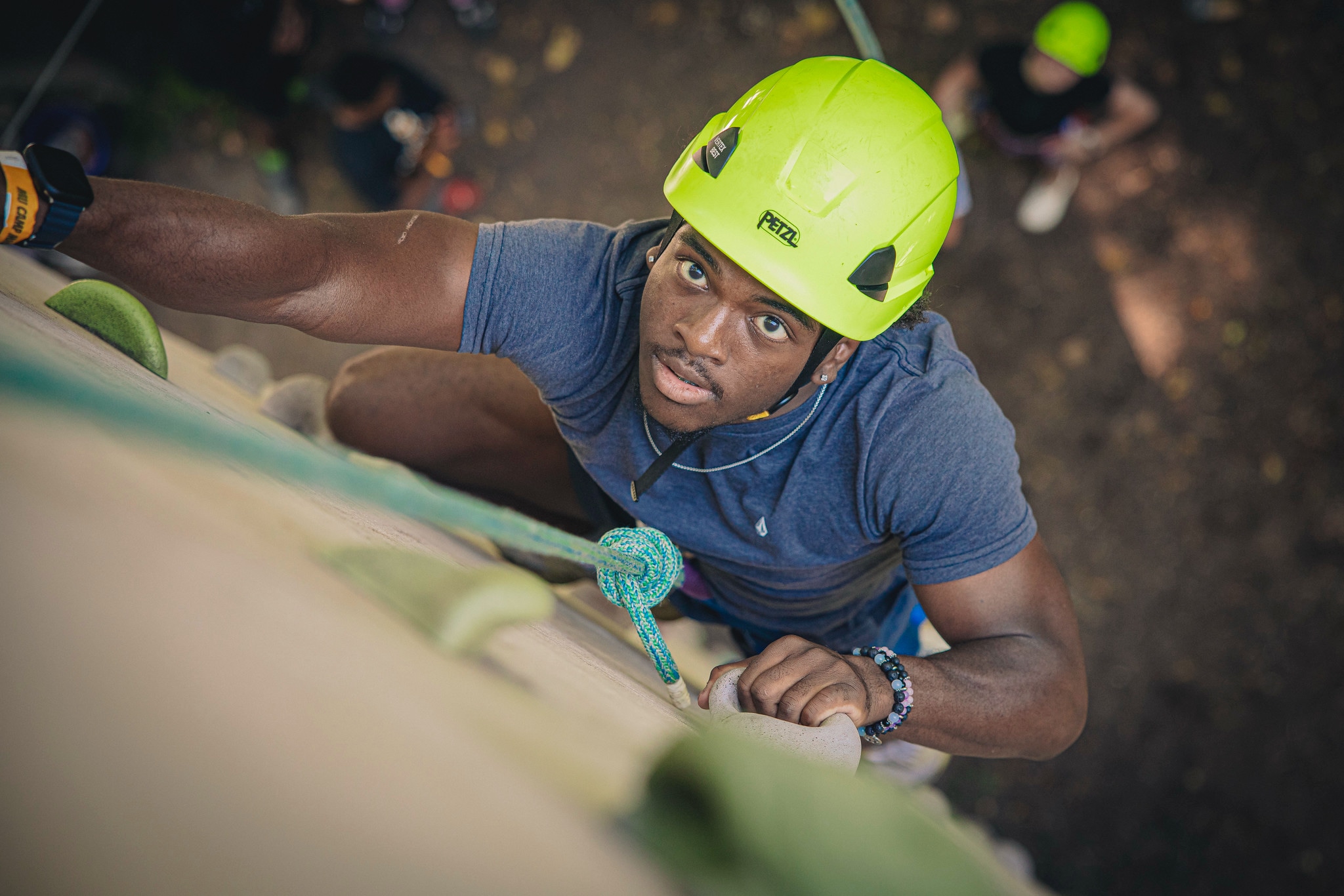 male student with yellow hard hat outside repelling Camp Mack Day