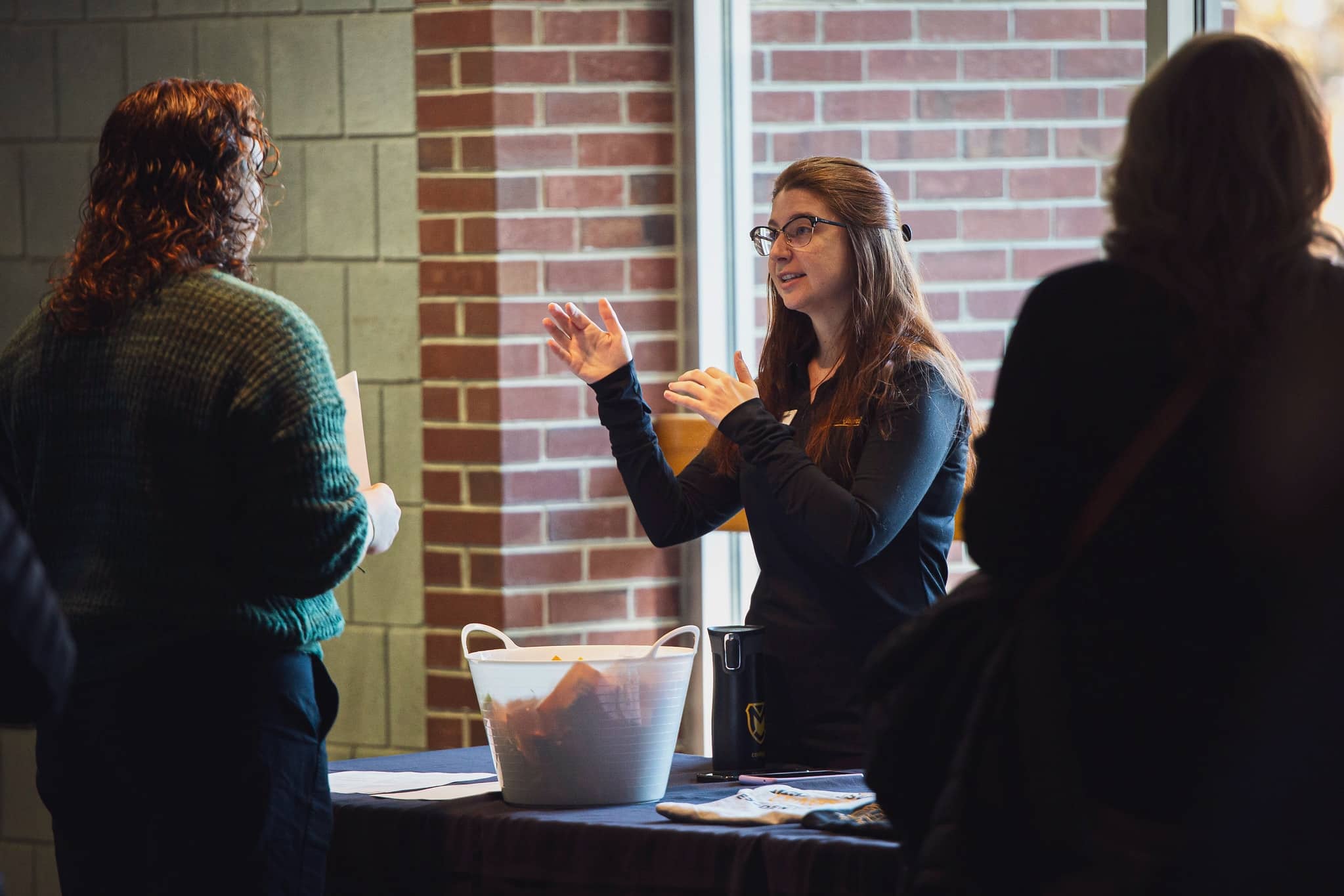 student talking to families at table on a visit day