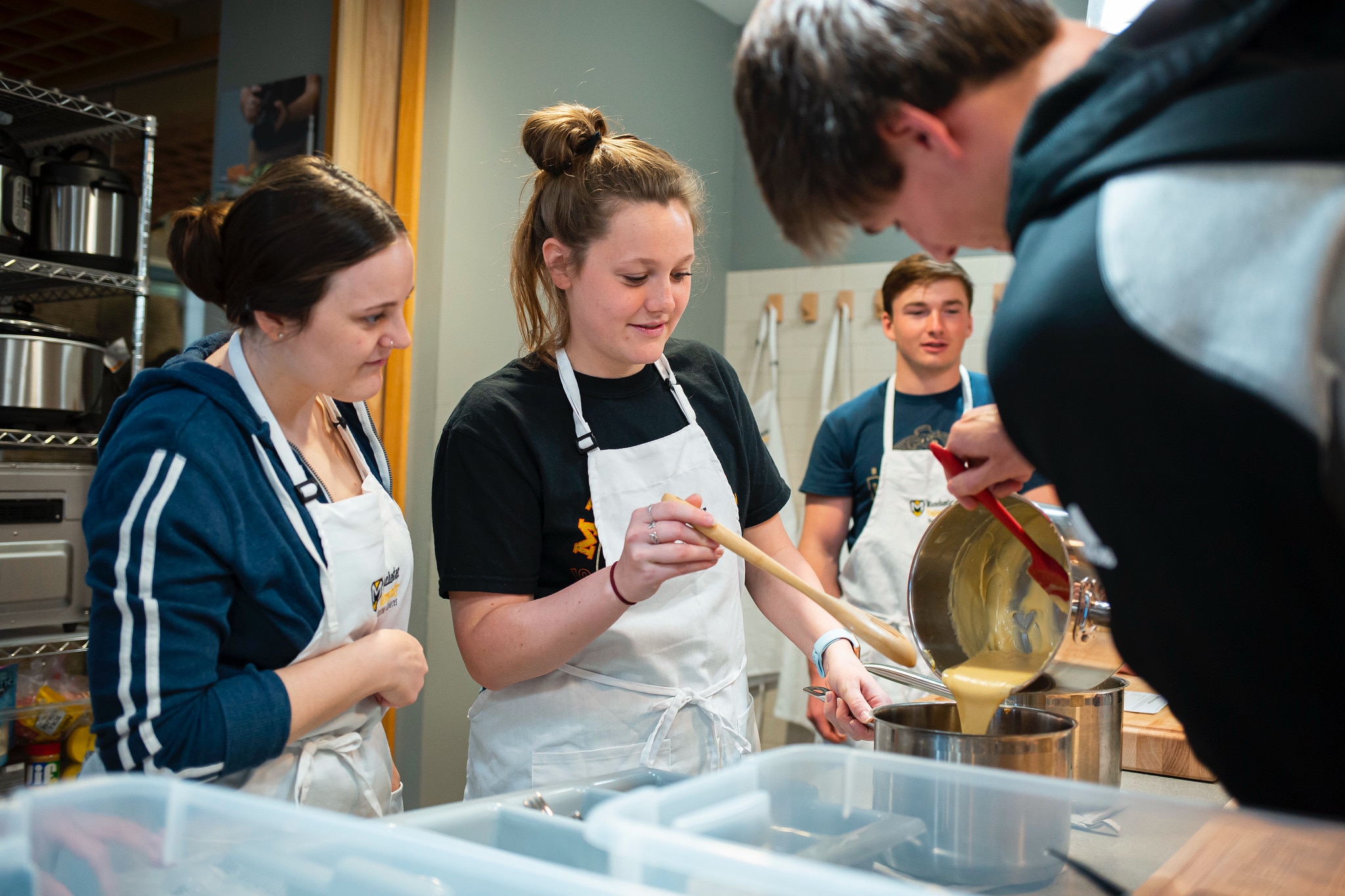a group of nutrition students prepare a recipe during class