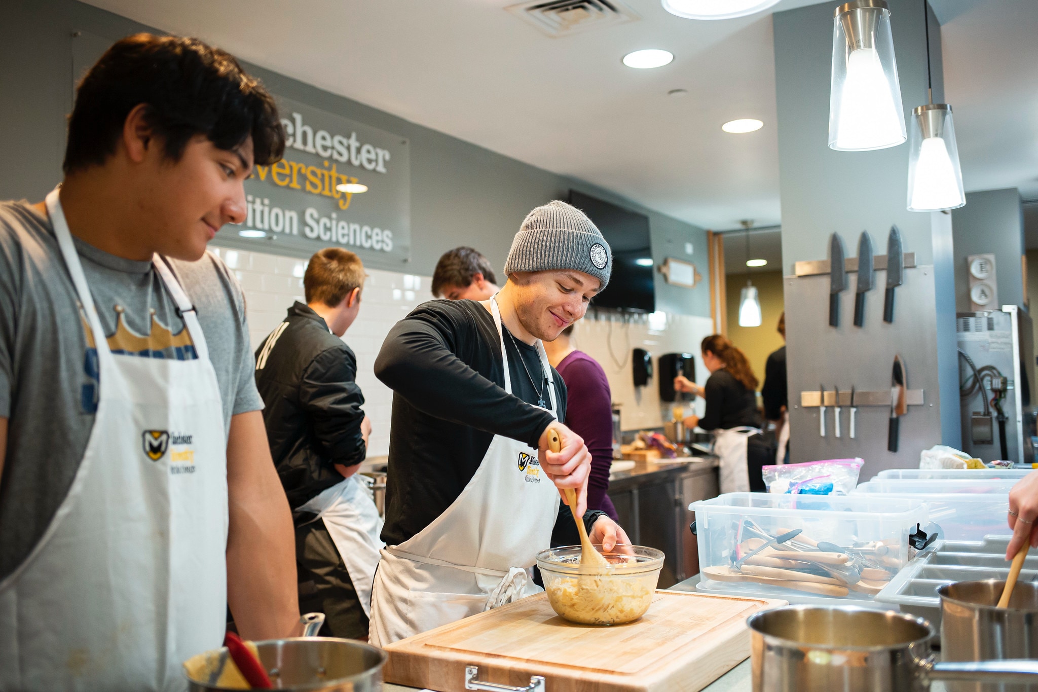 two males students prepare a pasta recipe during a nutrition class