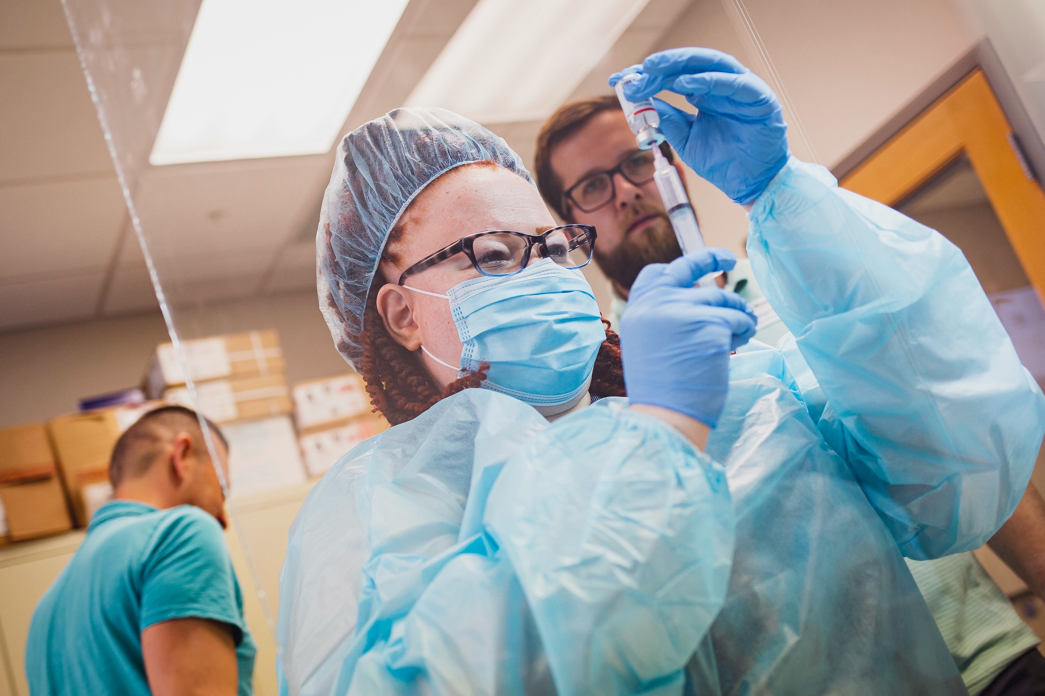 a female pharmacy student dressed in a surgical gown measures a medication