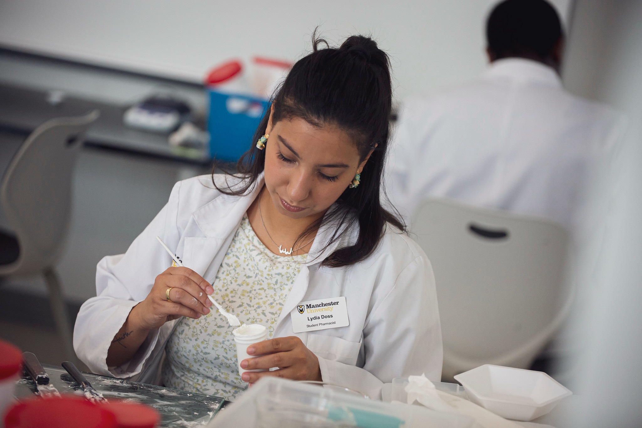 Pharmacy-8 a female pharmacy student measures a powdered medication