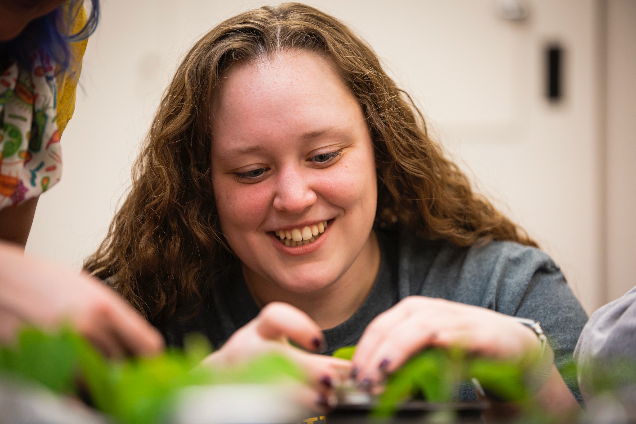 PlantResearch-7 a female student smiles as she studies a plant