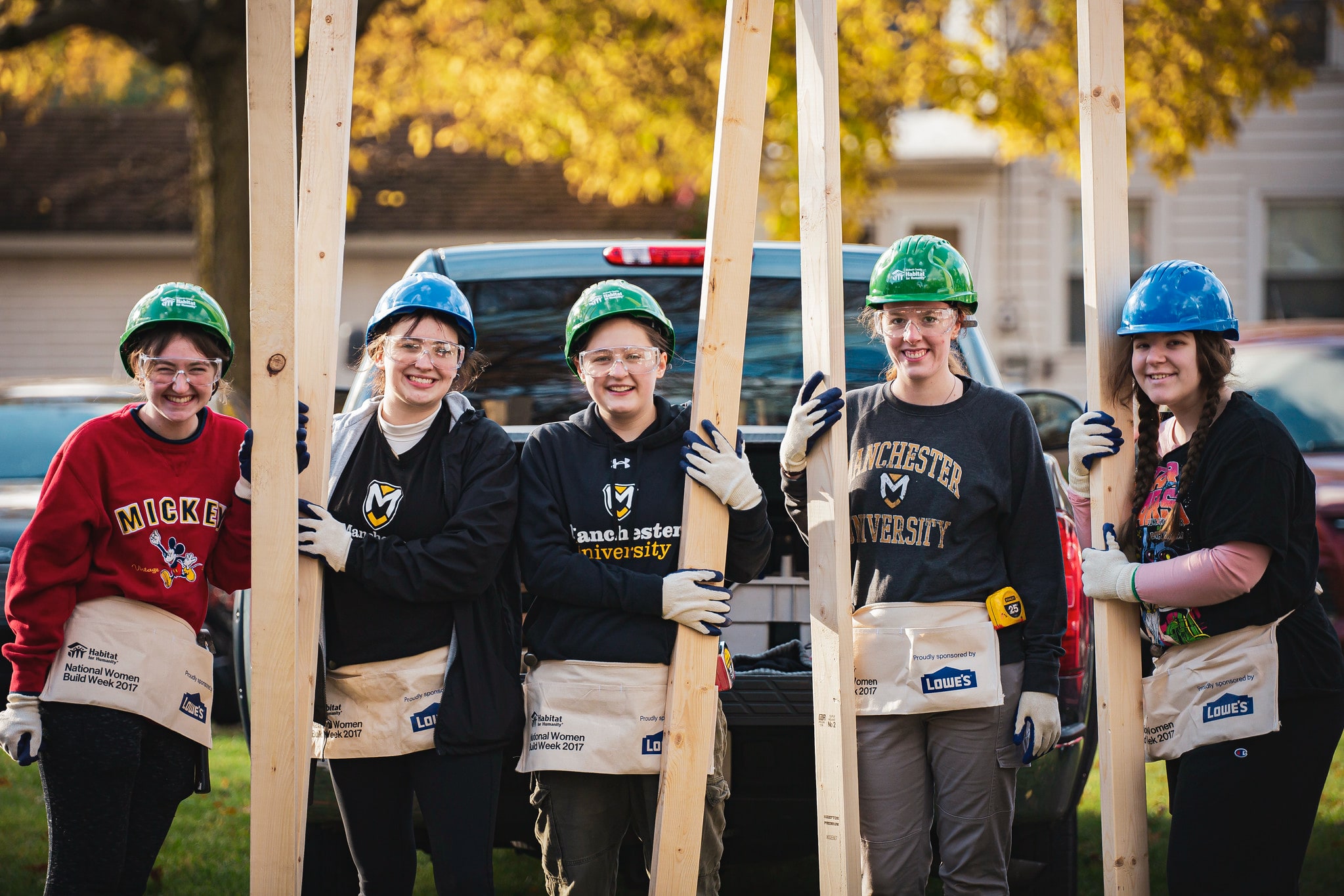 a group of manchester students hold boards during a service project