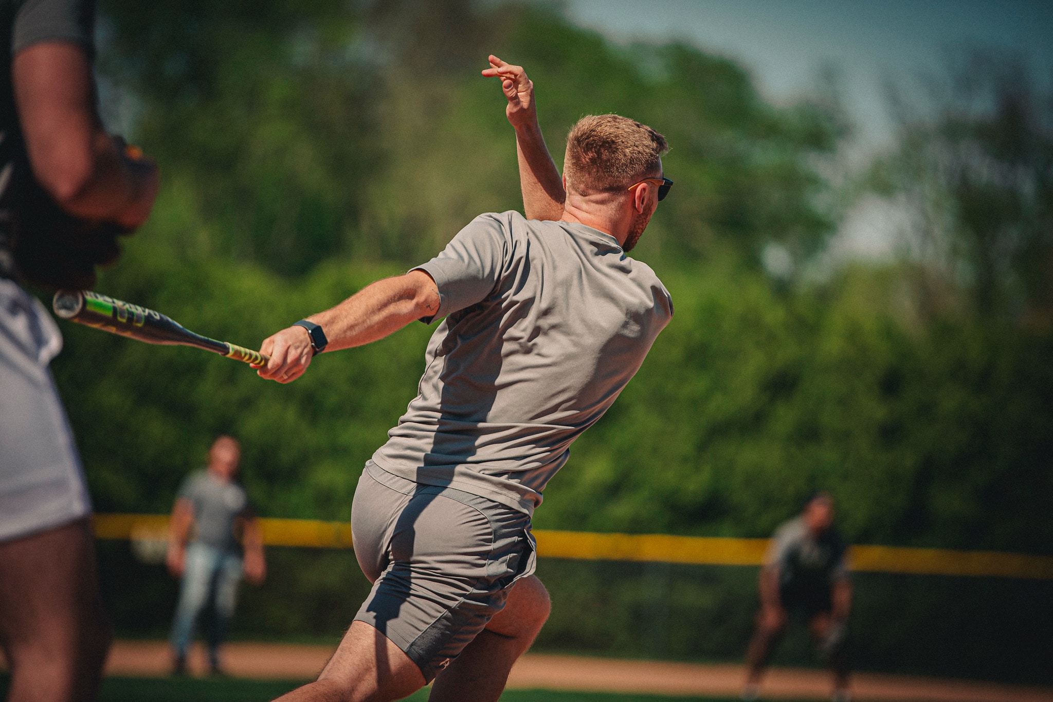 male student running to first base after hitting a softball