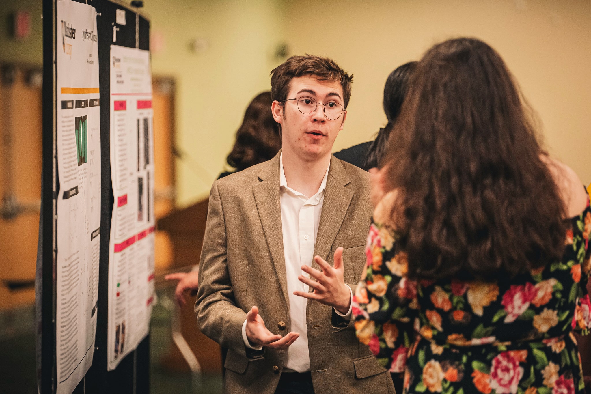 Symposium-15 student presenting research to another student