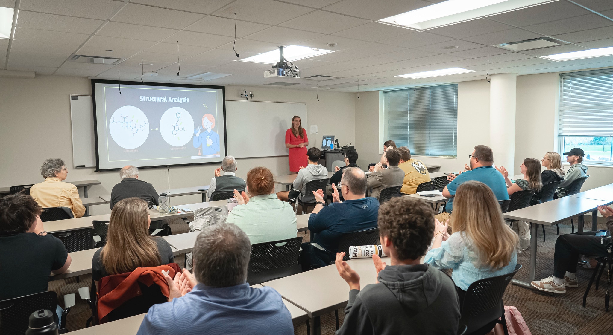 student giving a presentation in a classroom during a symposium