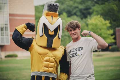 manny-with-student-flexing male student flexes with manny the mascot