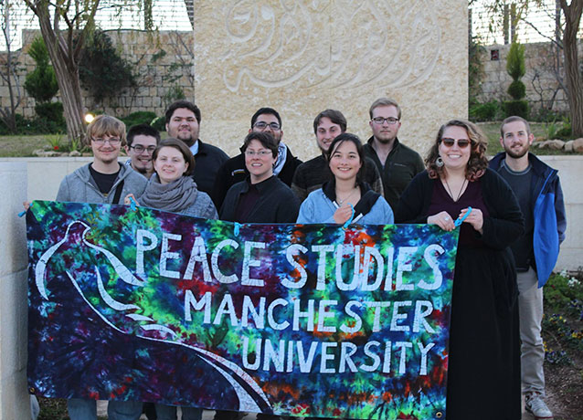 Lucas with other students holding a Peace Studies banner