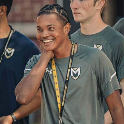 AdmissionsMenuImg A student of color smiles and looks on during the Week of Welcome