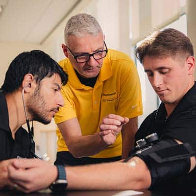 DPTMenuImg In a DPT lab, an instructor from MU teaches about blood pressure with 2 students