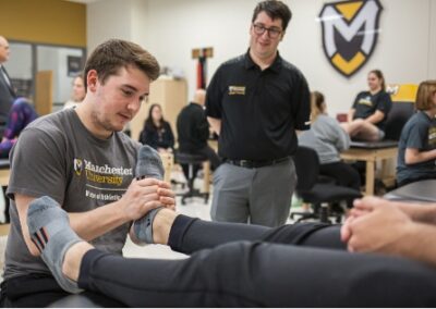Athletic Training student at Fort Wayne assessing and evaluating foot injury