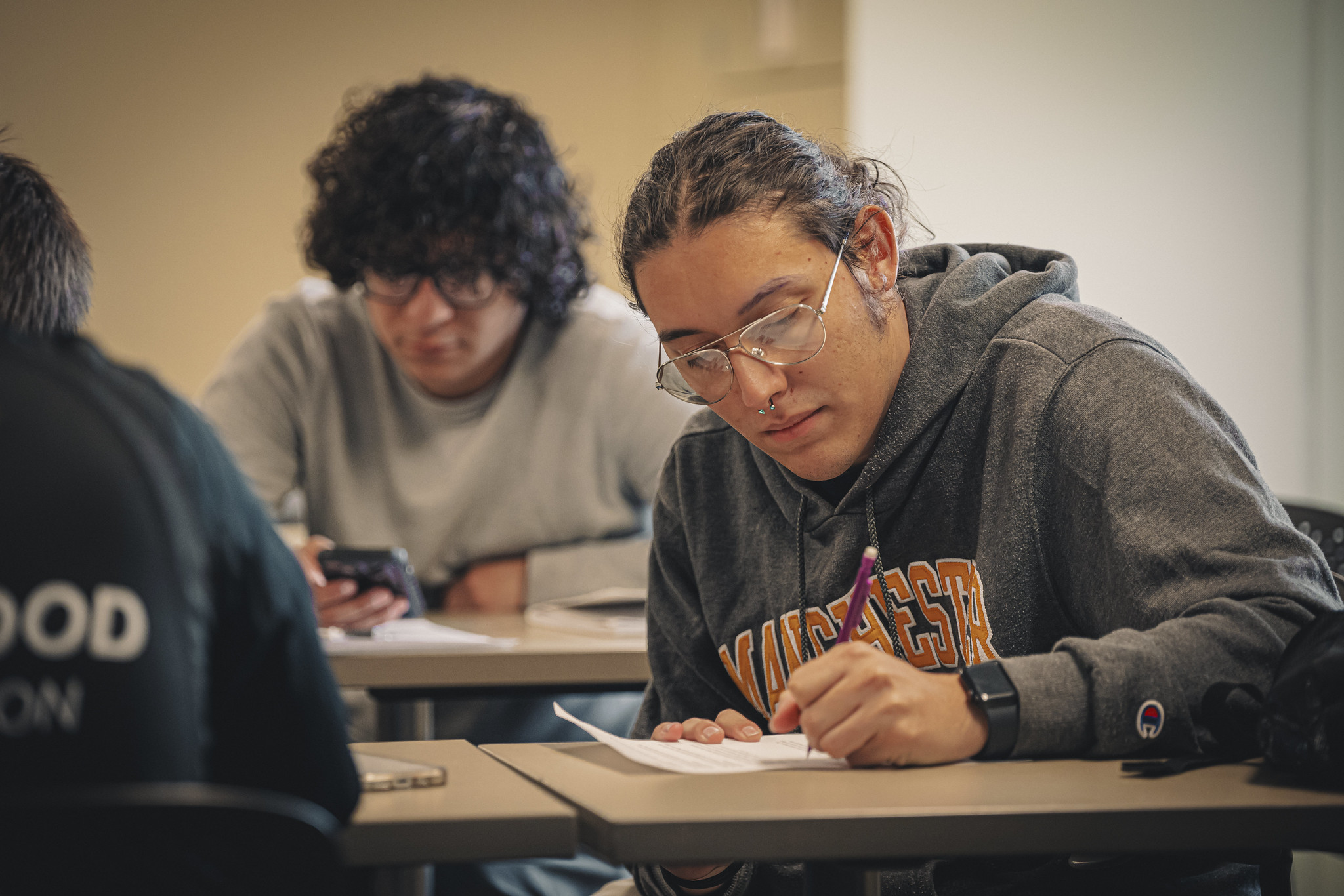 Manchester University male transfer student taking test in classroom Manchester University male transfer student taking test in classroom