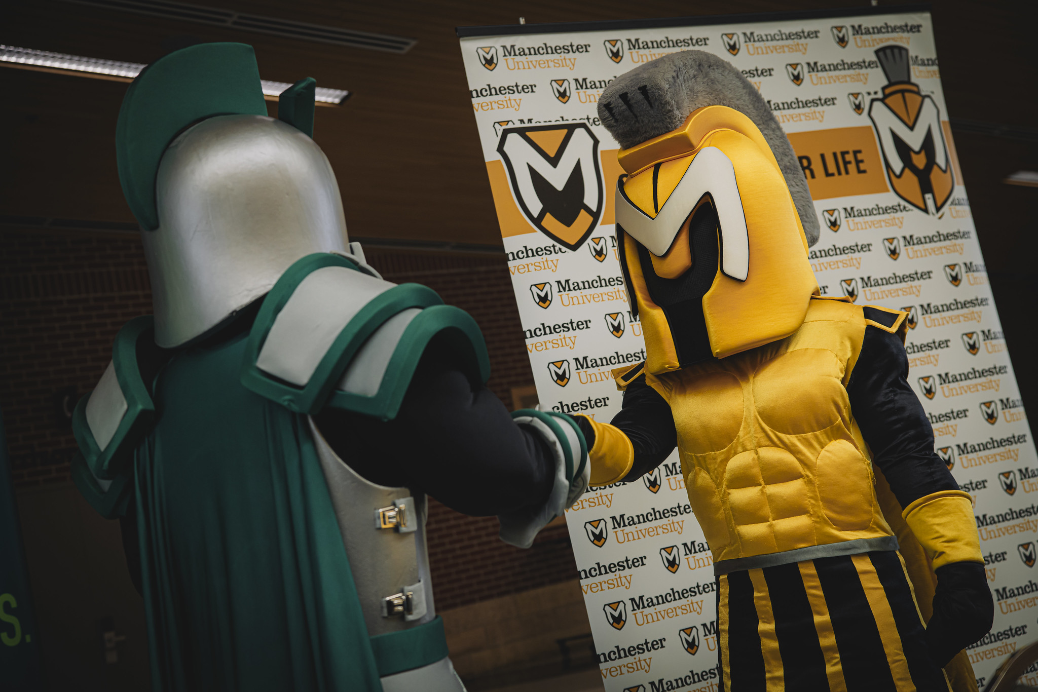 Manny the Macot shaking hands with another mascot Manny the Macot shaking hands with another mascot