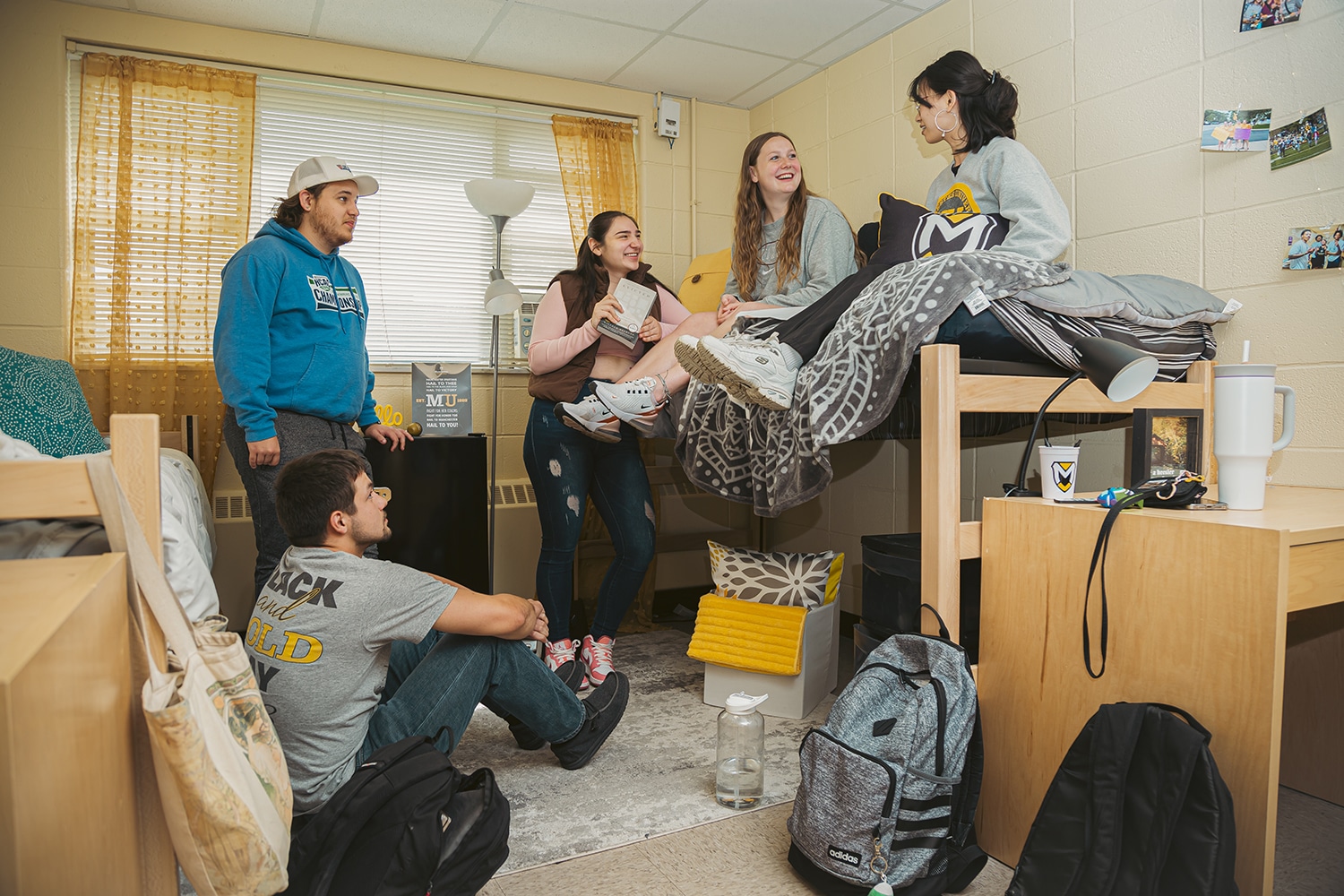 students-dormroom-web Five students hang out and laugh in a dorm room in Garver Hall, Manchester University. One student is sitting, some standing, and some sitting on a lofted bed.
