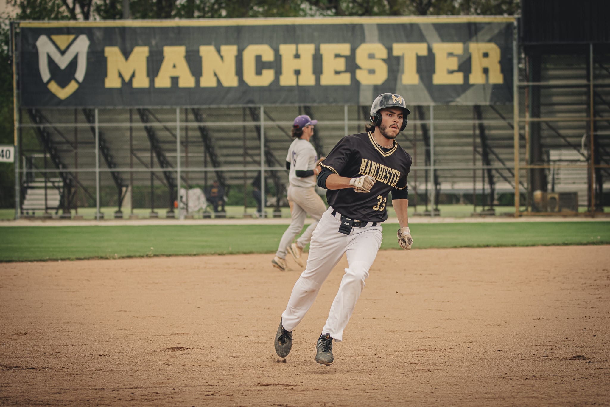 Manchester University baseball player gets ready to round third base on Gratz Field