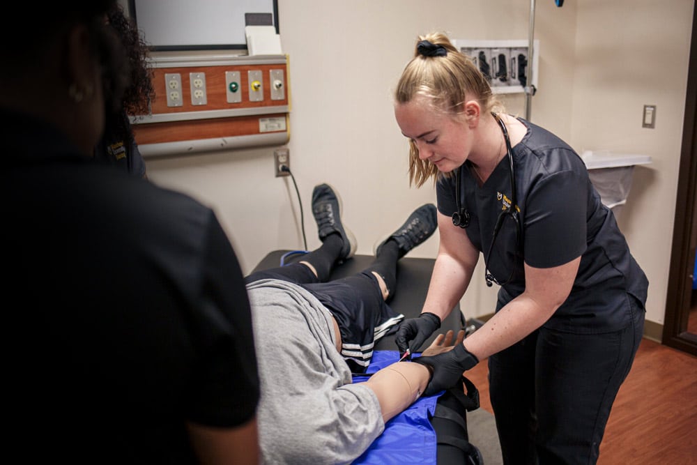 Nurse_Questa_Parkview_Bedside A female Manchester University student practices bedside nursing.