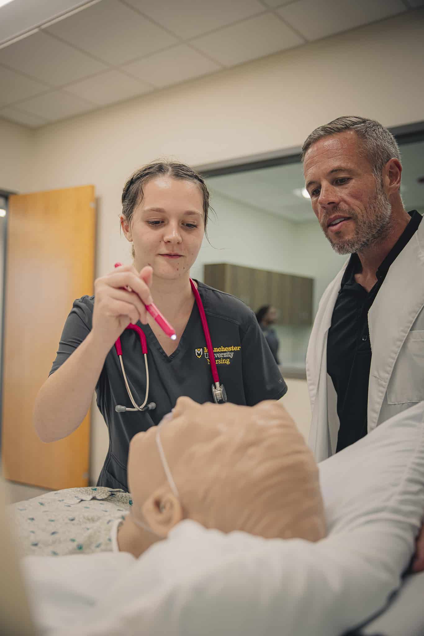 A nursing student learns from assistant dean Dustin Diller. 