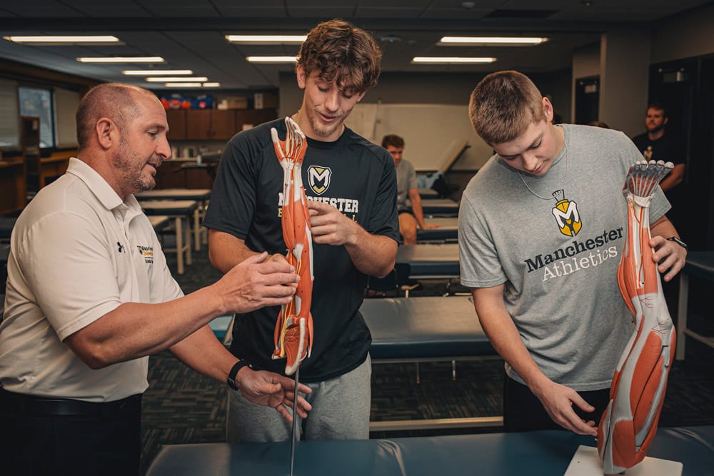 2 male students are introduced to the musculoskeletal system in the CRS lab at MU by Dr Jeff Beer