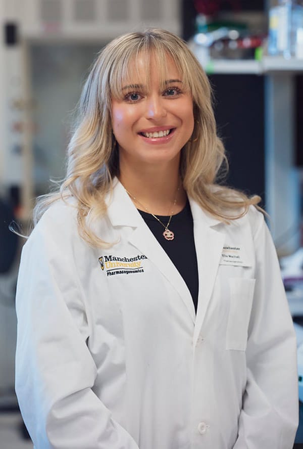 A female PGx student from Manchester University Fort Wayne dressed in a white lab coat.