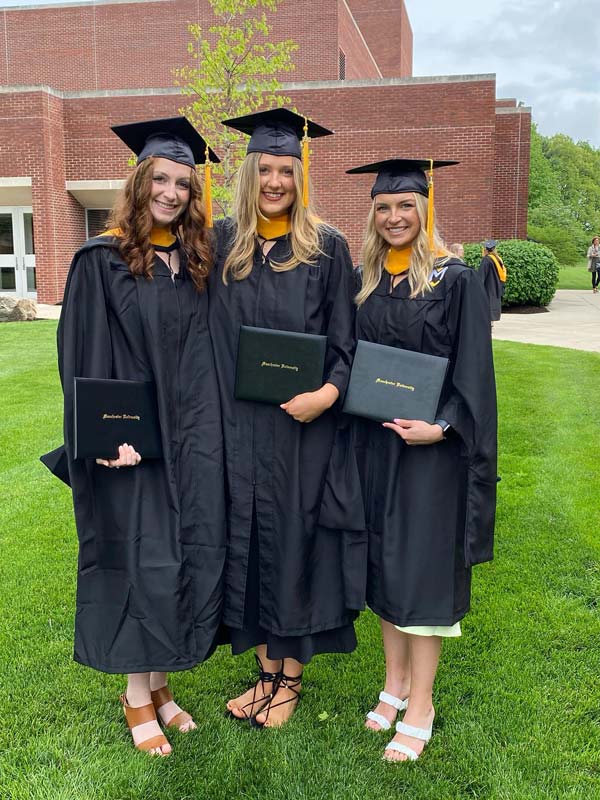 3 female students pose for a photo during commencement ceremony