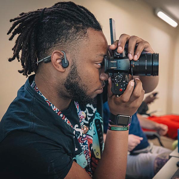 A student practices using a digital camera