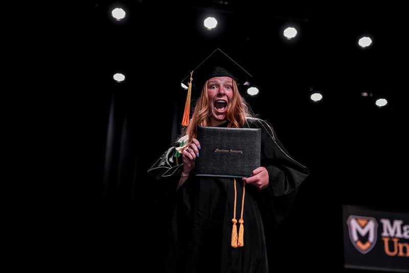 student celebrates walking across stage