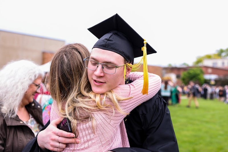 Graduate hugging and celebrating at Manchester University commencement