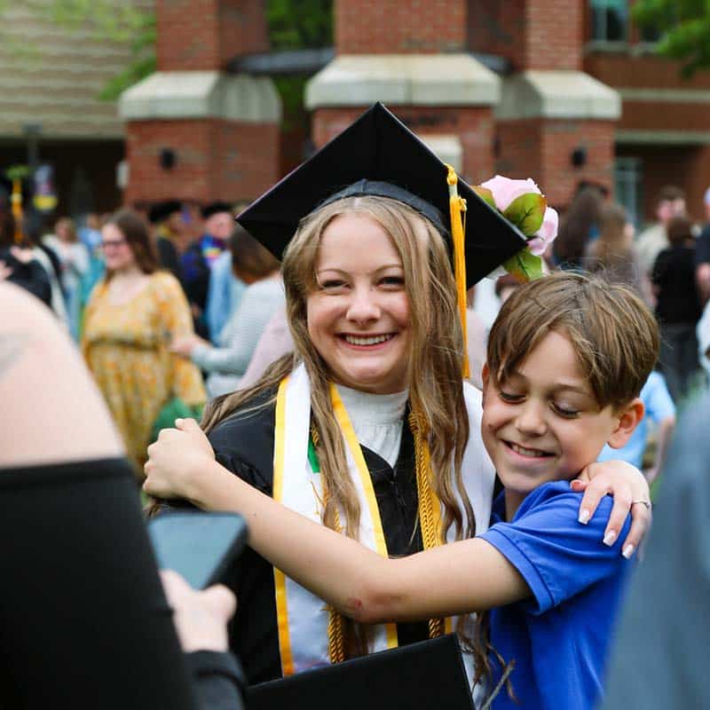A female grad celebrates with her family on commencement day.