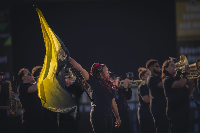 Flag girl with a golden flag during homecoming week.