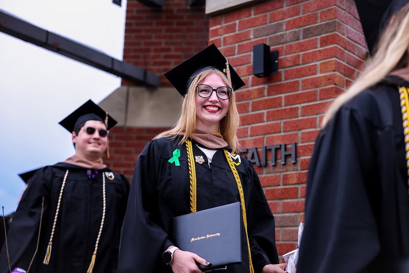 A female student carries her diploma through the chime as is tradition