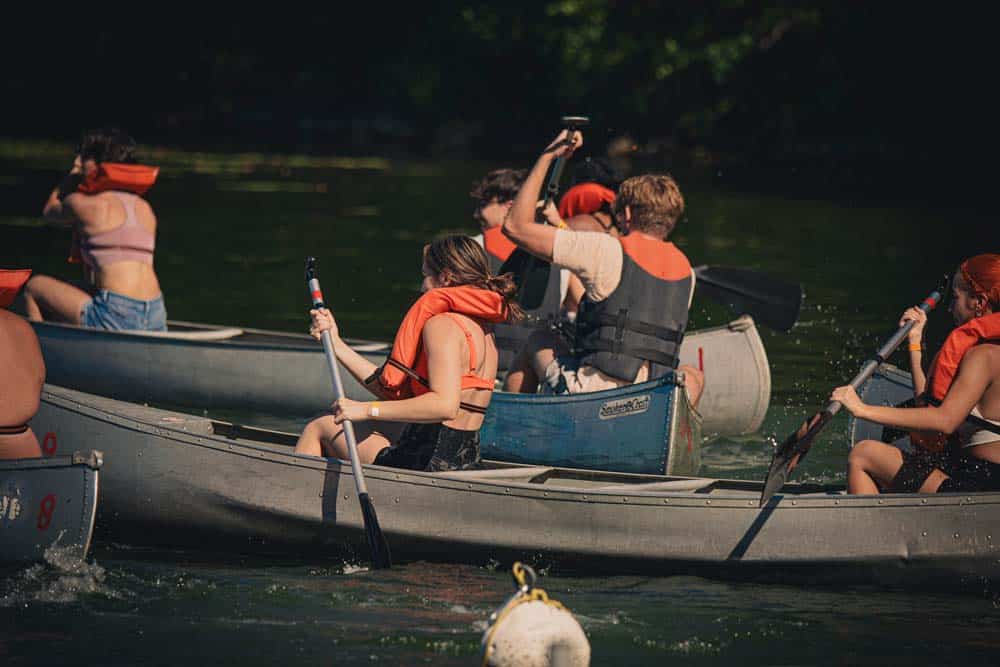 Students participate in a canoeing competition at Camp Mack