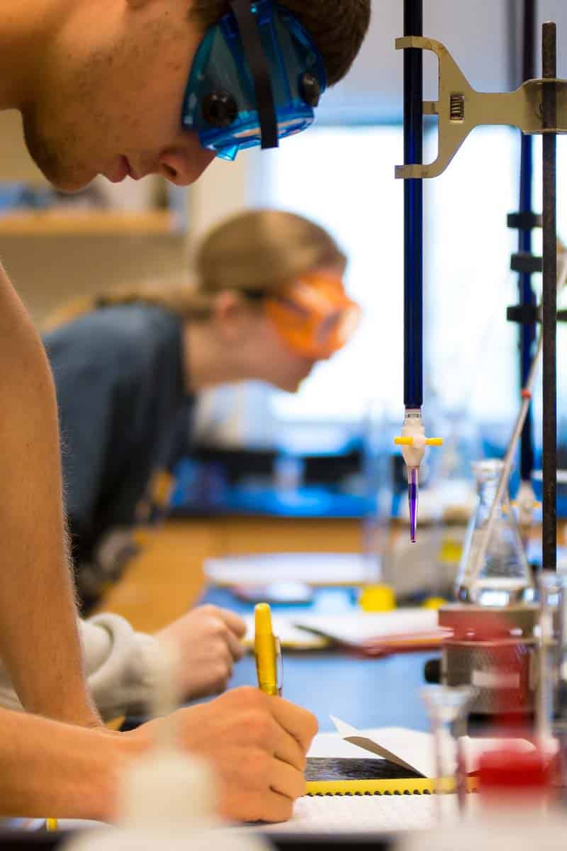 BioChemPreProPath A student in the bio-chem lab on MU North Manchester Campus writes notes near a beaker.