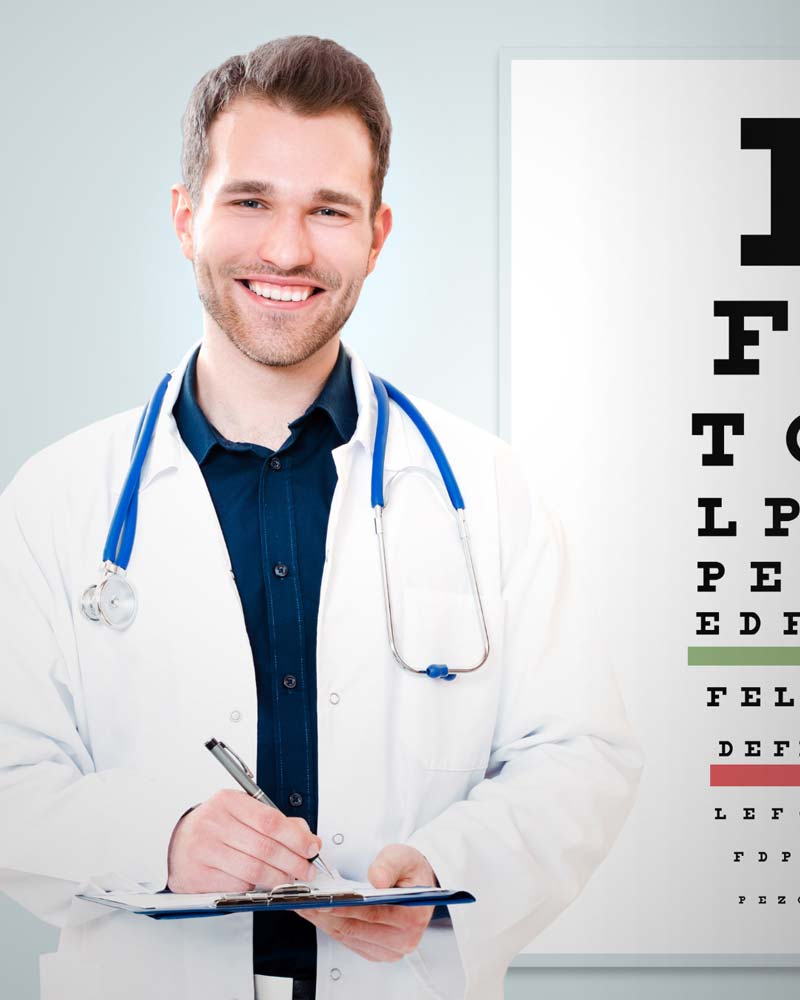 An optometrist stands before a standard eye exam chart while holding a clipboard.