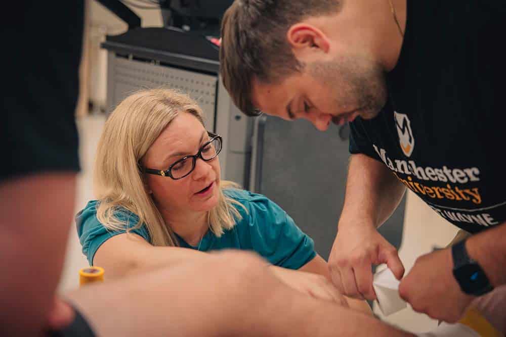 Julie Lies shows a demonstration of tape wrapping around an ankle. 